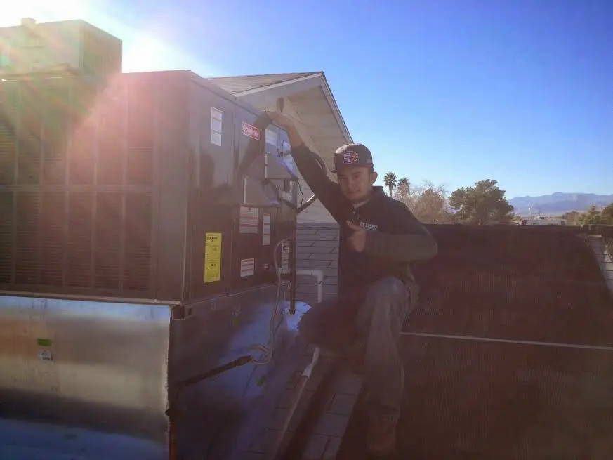 HVAC technician performing Boiler Repair on a rooftop unit in Ames